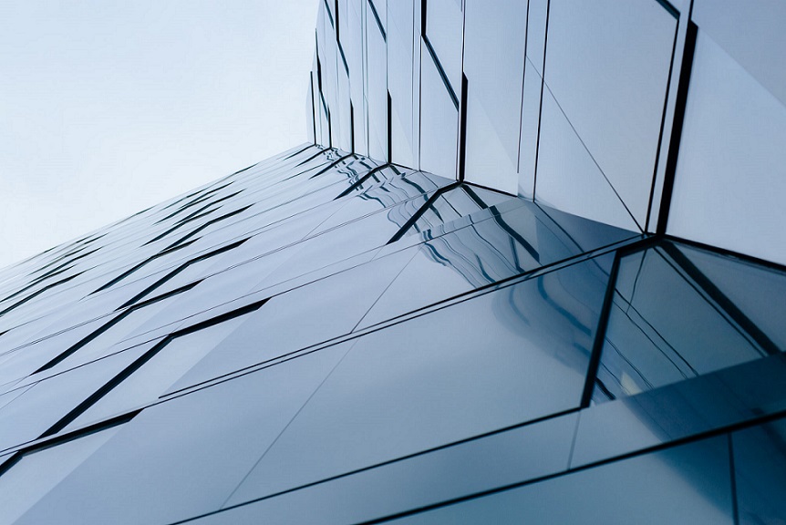 Dark glass facade of the university library reflecting an overcast sky